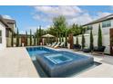 Inviting pool and spa featuring sun loungers, landscaped with manicured trees and plants for privacy at 7974 Chilton Dr, Orlando, FL 32836