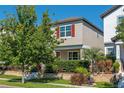 Charming two-story home with a red door, gray exterior paint and well-manicured landscaping at 9348 Meadow Hunt Way, Winter Garden, FL 34787