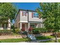 Charming two-story home with a red door, gray exterior paint and well-manicured landscaping at 9348 Meadow Hunt Way, Winter Garden, FL 34787