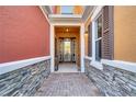 Inviting entrance showcasing brick pavers, stone accents and covered entrance offering an appealing welcome at 9559 Silver Buttonwood St, Orlando, FL 32832