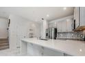 Bright kitchen featuring gray cabinets, stainless steel appliances, quartz countertops, and stylish backsplash at 10221 Highline Crest St, Orlando, FL 32832