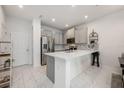 Modern kitchen featuring sleek stainless steel appliances, gray cabinets, stylish backsplash, and a large island at 10221 Highline Crest St, Orlando, FL 32832