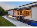 Backyard oasis featuring a modern pool, fire feature, and an outdoor seating area with a grill at 1211 Munster St, Orlando, FL 32803