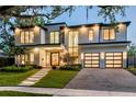 Modern two-story home featuring a manicured lawn, lush landscaping, and an attached two-car garage at 1211 Munster St, Orlando, FL 32803
