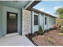 Inviting entrance with stone accents, a modern door, and fresh landscaping, creating curb appeal at 1360 Gladiolas Dr, Winter Park, FL 32792