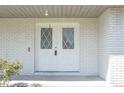 Eye-level shot of a white double door entry with diamond-shaped windows at 1668 Fort Smith Blvd, Deltona, FL 32725