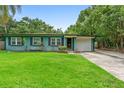 Charming one-story home featuring a well-manicured lawn, driveway, and mature trees at 1805 Paloma Ave, Sanford, FL 32771