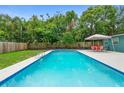 Inviting backyard pool area featuring outdoor dining space and lush landscaping at 1805 Paloma Ave, Sanford, FL 32771