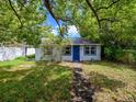Charming home with mature trees, lush green grass, and a blue front door at 1979 Staunton Ave, Winter Park, FL 32789