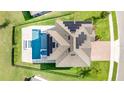 An aerial view shows the roof with solar panels and a sparkling pool with manicured landscaping at 2060 Panoramic Cir, Apopka, FL 32703