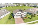 Aerial view of a beautiful home with solar panels, brick driveway, and spacious green lawn in a Gathering-friendly neighborhood at 2060 Panoramic Cir, Apopka, FL 32703