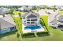 Gorgeous home featuring a private pool and spa, complemented by lush landscaping and a black metal fence at 2060 Panoramic Cir, Apopka, FL 32703