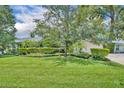 Single story home with green lawn, manicured landscaping and mature tree in the front yard at 2081 Mohican Trl, Maitland, FL 32751