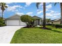 Inviting home exterior featuring a spacious three-car garage, well-maintained lawn, and beautiful shrubbery at 2135 Springwater Ln, Port Orange, FL 32128