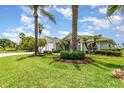 Beautifully landscaped front yard featuring vibrant green lawn, mature trees, and manicured shrubbery at 2135 Springwater Ln, Port Orange, FL 32128