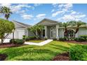 Charming single-story home with well-manicured lawn, lush landscaping, and inviting walkway at 2135 Springwater Ln, Port Orange, FL 32128