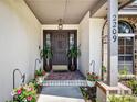 Inviting front entrance with a decorative door, potted plants, brick accents, and stylish house numbers at 2209 Fairglenn Way, Winter Park, FL 32792