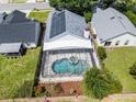 Aerial view of a screened-in pool, spa, solar panels, and the backyard of the house at 3055 Dellcrest Pl, Lake Mary, FL 32746
