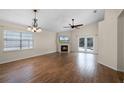 Bright living room featuring a fireplace, wood floors, a ceiling fan, and French doors to the pool at 3055 Dellcrest Pl, Lake Mary, FL 32746