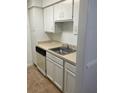 Galley kitchen featuring white cabinets and a stainless-steel sink at 315 Wymore Rd # 104, Altamonte Springs, FL 32714