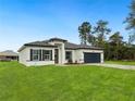 Charming single-story home with black shutters and a manicured lawn, perfect for a welcoming entrance at 3420 Sw 130Th Lane Rd, Ocala, FL 34473