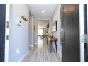 Inviting entryway featuring light wood flooring, a modern console table, and a view into the brightly lit living area at 4414 Le Reve Ct, Kissimmee, FL 34746