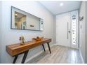 Bright entryway with light tile flooring, a stylish wood console table with metal legs, and a decorative mirror at 4414 Le Reve Ct, Kissimmee, FL 34746
