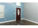 Bright entryway featuring a tall ceiling, wood-look flooring, fresh paint, and a decorative front door with sidelight at 5165 Mystic Point Ct, Orlando, FL 32812