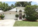 Inviting single-story home with a classic front door, manicured landscaping, and an attached two-car garage at 5165 Mystic Point Ct, Orlando, FL 32812