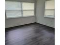 Bright bedroom with two large windows and sleek flooring; a serene retreat at 5416 Vance Ave, Orlando, FL 32810