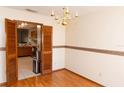 Traditional dining room with hardwood floors and a stylish chandelier, offering a glimpse into the kitchen at 596 Starstone Dr, Lake Mary, FL 32746