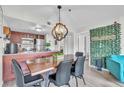 View of dining area with stylish table and seating and kitchen with stainless appliances at 6337 Parc Corniche Dr # 2312, Orlando, FL 32821