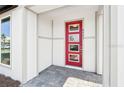 Inviting front entry with a red door featuring decorative glass panels and gray paver stones at 6723 Sherpa Trl, St Cloud, FL 34771