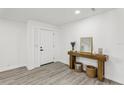 Bright entryway featuring wood-look floors, a console table with decorative items, and a modern interior door at 7124 Turquoise Ln, Orlando, FL 32807