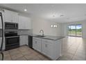 A stylish kitchen features stainless appliances, gray counters and tile flooring at 877 Ocean Course Ave, Davenport, FL 33896