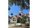 Attractive two-story building with red awnings, lush landscaping, and a charming fountain at 11582 Westwood Blvd # 1428, Orlando, FL 32821