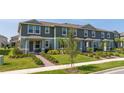 Charming row of townhomes, each featuring a covered entrance and beautifully landscaped front yards at 13452 Sagestone Dr, Winter Garden, FL 34787