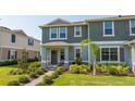 Inviting two-story townhome with well-manicured lawn and landscaped walkway leading to the covered porch at 13452 Sagestone Dr, Winter Garden, FL 34787