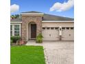 Inviting single-Gathering home with stone accents, a two-car garage, and a well-manicured lawn at 13842 Pickett Reserve Ct, Orlando, FL 32826