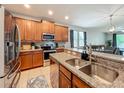 Modern kitchen features stainless steel appliances, granite countertops, and wooden cabinetry at 13842 Pickett Reserve Ct, Orlando, FL 32826