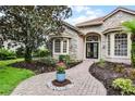 Charming stone and stucco home with a brick pathway and meticulously landscaped front yard at 1453 Langham Ter, Lake Mary, FL 32746