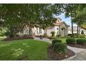 Well-maintained home boasting a brick walkway, manicured lawn, stone accents, and lush, mature trees at 1453 Langham Ter, Lake Mary, FL 32746