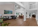 Bright and airy living room with hardwood floors, soaring ceilings, and a loft overlooking the open floor plan at 1610 Owl Ridge Ct, Apopka, FL 32712