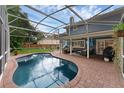 Beautiful screened-in pool area with brick pavers, outdoor seating, and lush landscaping, perfect for relaxation at 1610 Owl Ridge Ct, Apopka, FL 32712