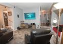 Cozy living room featuring tile floors, a large TV, comfortable leather recliners, and view into dining room at 2101 S Goldenrod Rd, Orlando, FL 32822