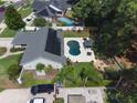 Expansive backyard with dark blue pool, cabana, fire pit and solar panels on roof at 2122 Palm Crest Dr, Apopka, FL 32712