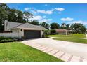Charming single-story home with a well-manicured front yard, a brick-lined driveway, and a two-car garage at 2122 Palm Crest Dr, Apopka, FL 32712