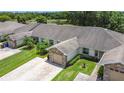 Aerial view of the villa community featuring a paved driveway, lush lawn, mature trees, and neighboring villas at 2724 Shelby Ruth Pl, St Cloud, FL 34769