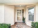 Inviting front porch with decorative plants, a storm door, and tiled flooring leading to the main entrance at 2724 Shelby Ruth Pl, St Cloud, FL 34769