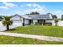 Inviting single-story house with a gray roof, solar panels, two-car garage, and well-kept front yard at 2832 Buccaneer Dr, Winter Park, FL 32792